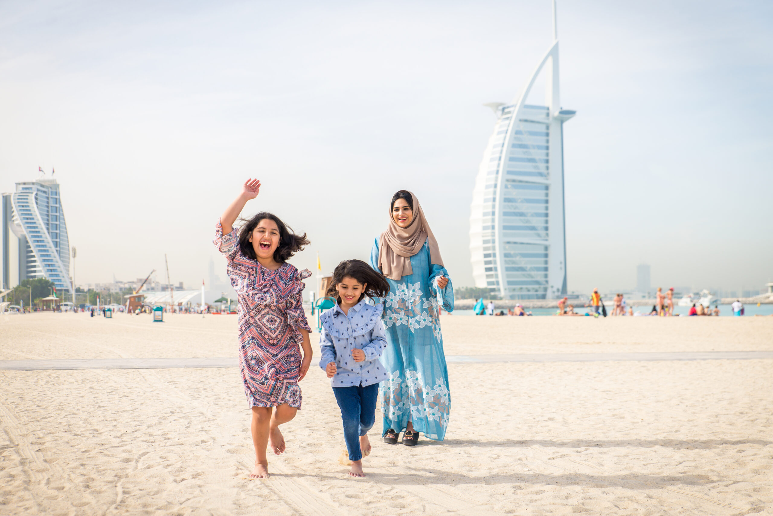 Happy arabian family having fun in Dubai – Mom together with her daughters on the beach